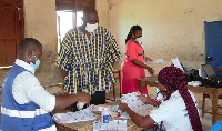 Mr. Robert Apechira Aloo interacting with EC staff at a centre in Paga