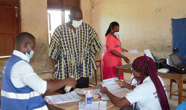 Mr. Robert Apechira Aloo interacting with EC staff at a centre in Paga