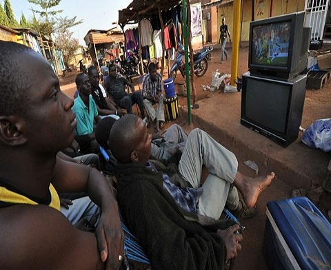 Group of men watching a television