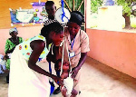 A health official weighing a child