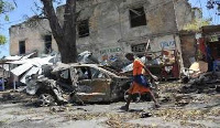 A boy walks past the site of a car bomb attack near a security checkpoint in Mogadishu