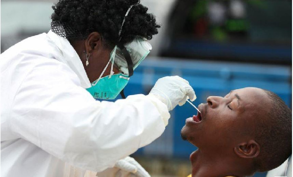 A member of medical staff swabs the mouth of a resident as she is testing him REUTERS/Siphiwe Sibeko