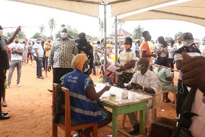 Mr Ishmael Ashitey middle observing the voter registration exercise at Mambrouk electoral area