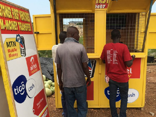 Customers at a Mobile Money vendor's shop