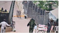 A security official instructs a member of the Force's bomb disposal experts