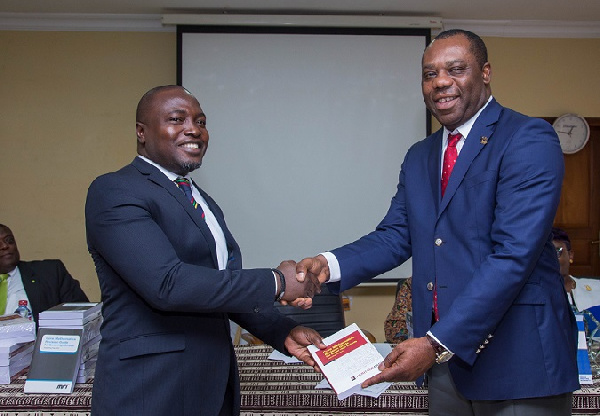 Mr Ebenezer Akyeampong of Heritage Bank presenting a copy of the book to Education Minister