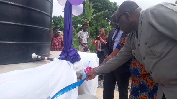 Michael Alabi and others cutting the tape to inaugurate  water project for  NJUASCO