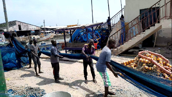 The fishermen were, among others, mending their nets, playing draft, chatting, and some sleeping