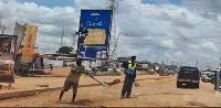 Some young men filling potholes on the road