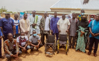 Officials of Sadaqa train and beneficiaries with some of the items (wheel chairs)