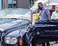 Sarkodie standing close to one of the cars