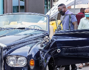 Sarkodie standing close to one of the cars