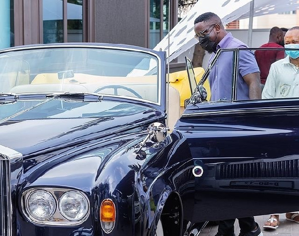 Sarkodie standing close to one of the cars