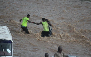 Men trying to save a woman who's been stranded in the floods