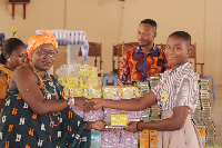 Naana Dugbakuwor Dugba II presenting some items to a BECE candidate