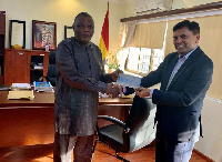 Mr. Agrawal, Country Head of Olam (R), presents the Cheque to Hon. Dr. Gyiele Nurah