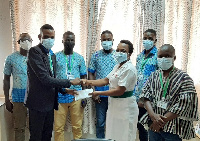 Photo of Mr Mahamadu Musah (left) presenting the cash to Mrs Justina Ayorobila Gockah