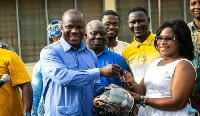 Samuel Abu Jinapor presenting a motorbike key to Madam Gertrude Yentumi