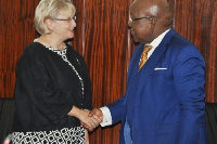 Professor Aaron Michael Oquaye in a handshake with Ms. Heather Cameron