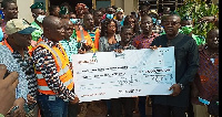 A Ghana Gas official (left) hands over a cheque to Prestea Bogoso MCE