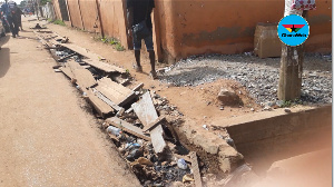 The gutter choked with waste and plastic materials