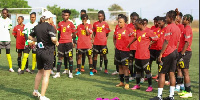 Black Queens head coach addressingg her players after a training session