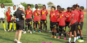 Black Queens head coach addressingg her players after a training session