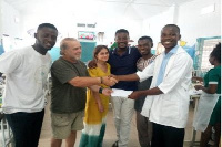 Mr Azongo (L) receiving cash donation from officials of the NGO at the Paediatric Department