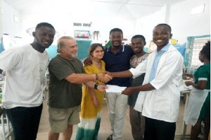 Mr Azongo (L) receiving cash donation from officials of the NGO at the Paediatric Department