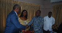 The MCE exchanges the document with Felix Nana Sackey of Delloitte & Touche