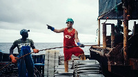 Chinese and local staff operate machinery on a fishing-boat