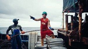 Chinese and local staff operate machinery on a fishing-boat