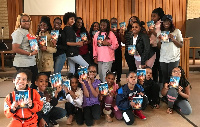 Havana Chapman-Edwards [in orange spacesuit kneeling left] with friends holding 'A Wrinkle in Time