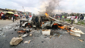 The shell of a police vehicle burnt by protesters along Mombasa Road in Mlolongo, Kenya