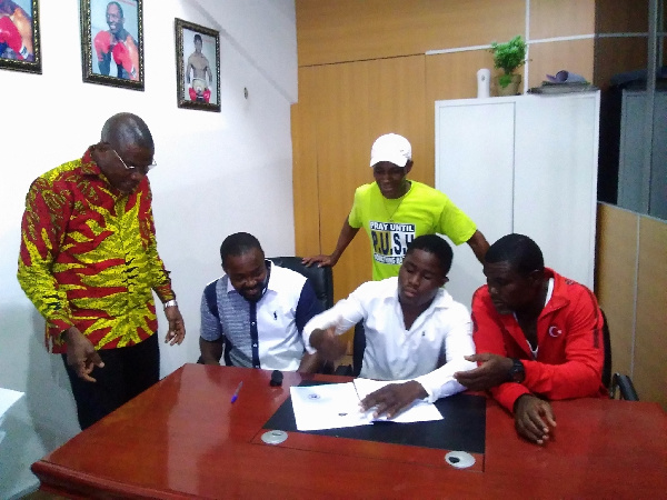 Derek Quaye signing the deal