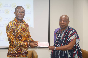 Joseph Boahen Aidoo, CEO of COCOBOD making the presentation to Health Minister [R]