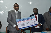 Affail Monney and Faris Attrickie displaying the dummy cheque after the signing ceremony