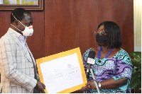 Justice Amoh presenting the cheque to Chief of Staff, Akosua Frema Osei Opare