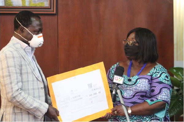 Justice Amoh presenting the cheque to Chief of Staff, Akosua Frema Osei Opare