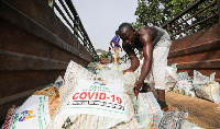 Men load sacks of rice among other food aid in a truck, to be distributed to people