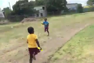 A young boy from Team Yellow running in an opposite direction