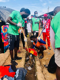 Players of Karela cleaning a gutter during the exercise