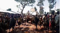 Congolese children run after a UN armoured personnel carrier at Rhoe IDP camp in Djugu