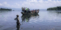 People get on a handmade wooden boat