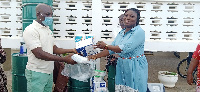 A rep of Amiki Club hands over items for donation