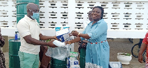 A rep of Amiki Club hands over items for donation