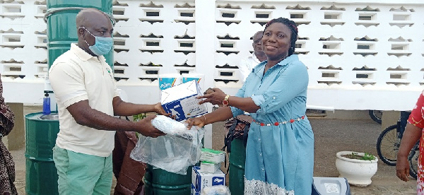 A rep of Amiki Club hands over items for donation