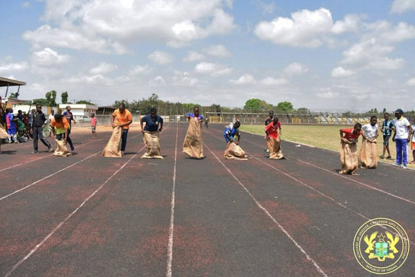 Some men and women in a sack race contest