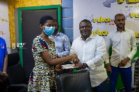 Collins Adomako-Mensah presenting the donation to Francisca Lamini of Keta SHS