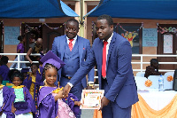 Chief Director of the school presenting a certificate to a pupil